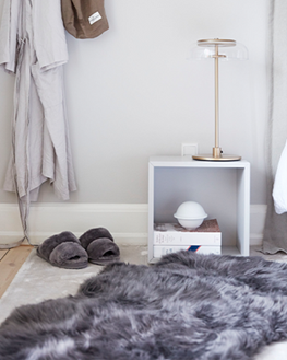 Langhaar Lammfellteppich neben einem Bett