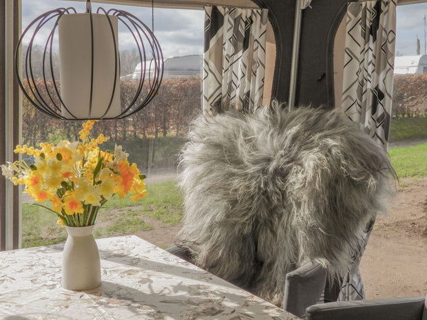 Graues Schaffell über einen Campingstuhl drapiert