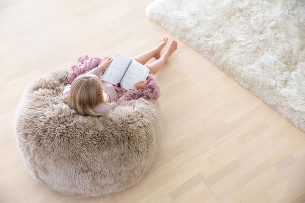 Mädchen liest im Fellstizsack