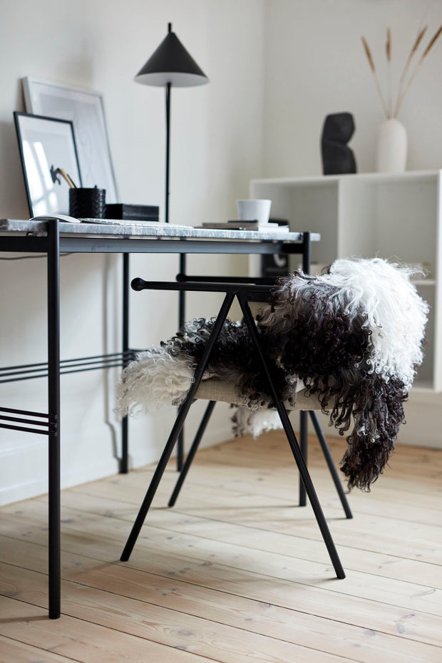 Lockiges Lammfell über Schreibtischstuhl drapiert