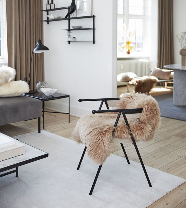 Rosa Lammfell auf Stuhl