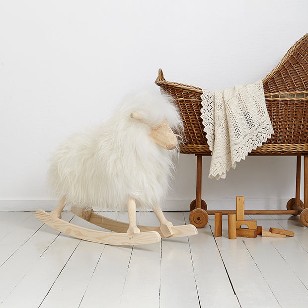 weisses schaukelschaf neben wiege